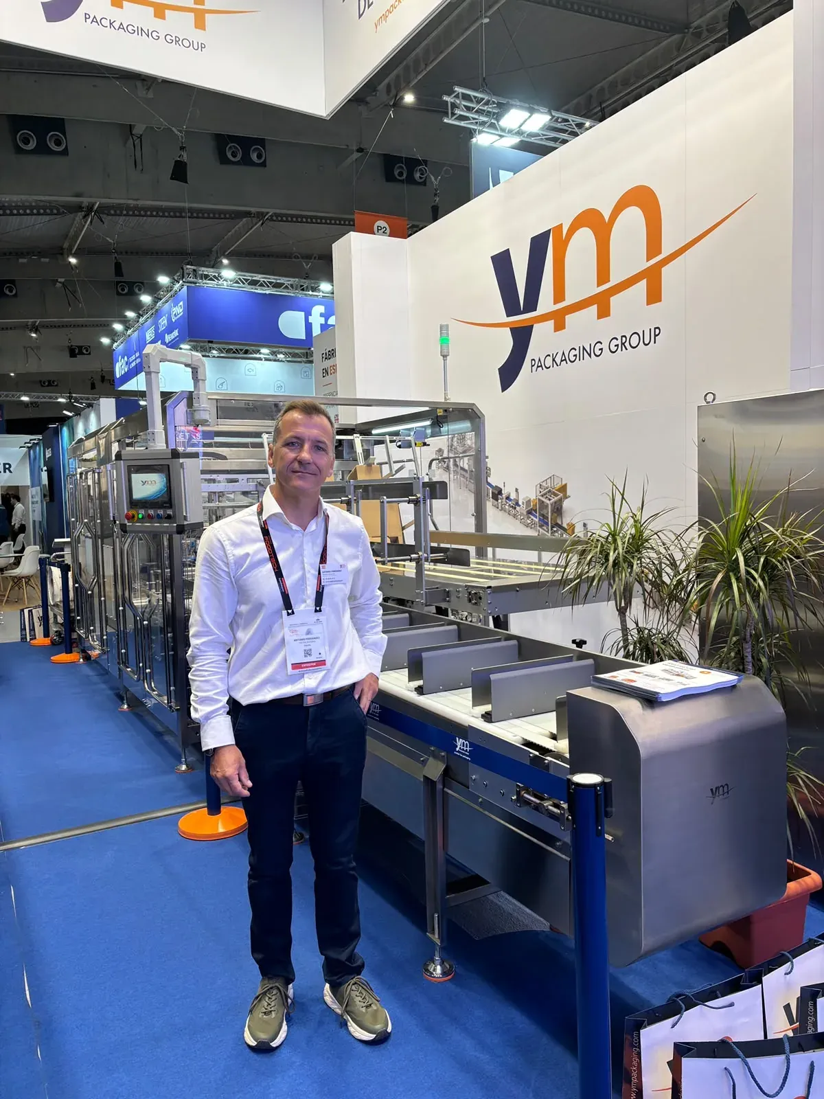 Equipo de YM Packaging junto a la encajadora EPCP-15 en FoodTech