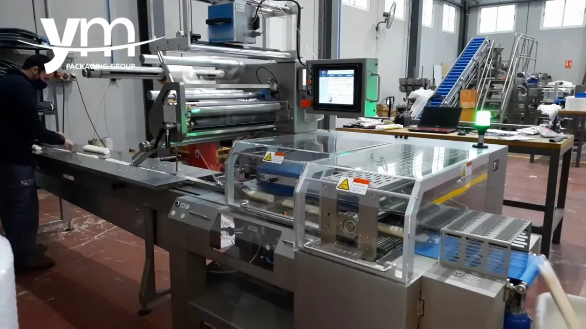 Envasadora FP600S con la bobina de film en el portabobinas y la cinta de entrada, en la planta de YM Packaging