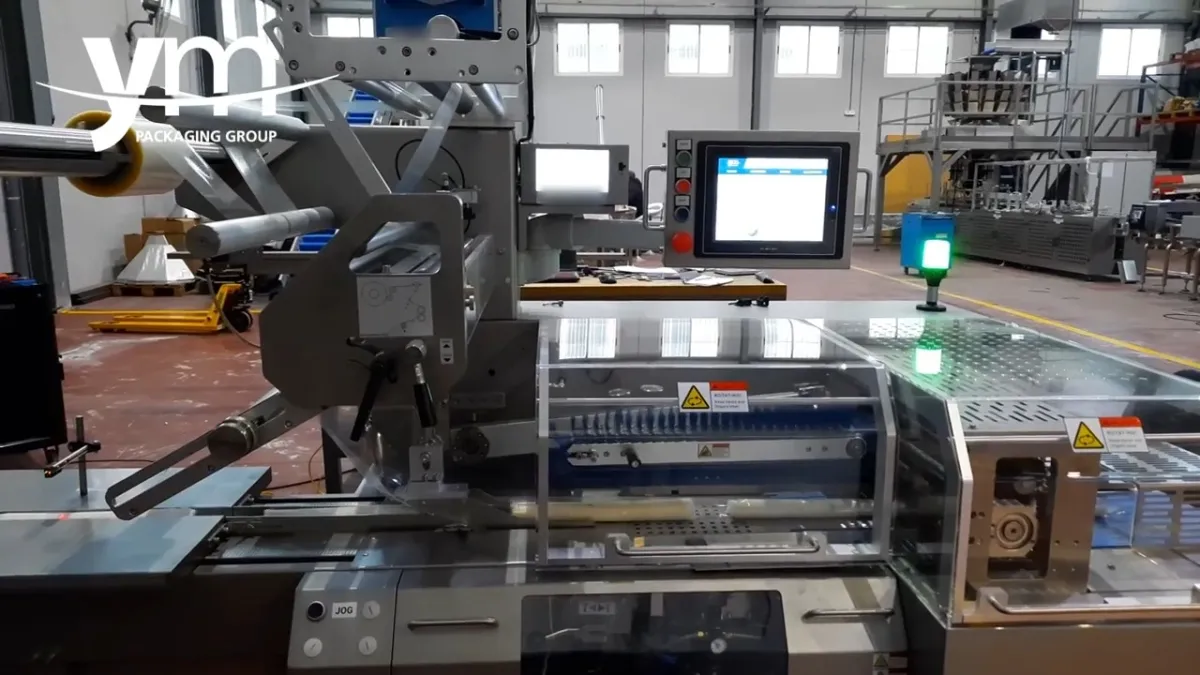 FP600S flow wrapping machine seen from the infeed, with the touch screen and transparent guards