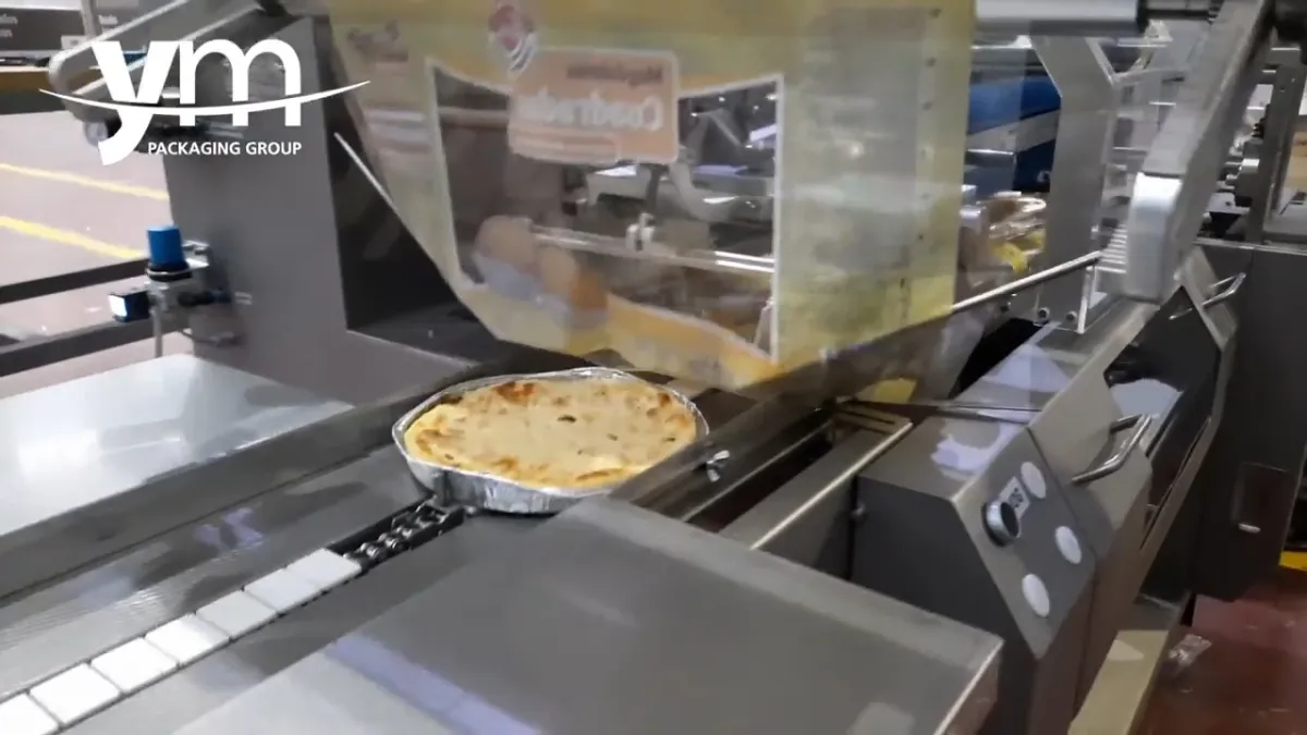Pizza in a tray entering the former of the flow wrapper