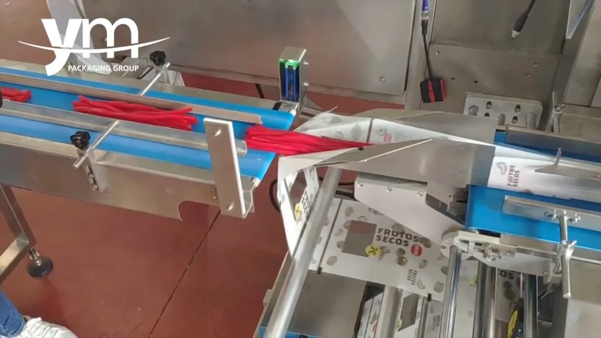 Liquorice sticks entering the printed film at the former