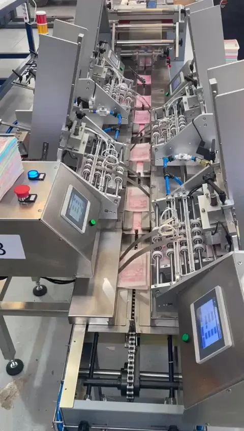 Línea de alimentadores automáticos con pantallas táctiles, delante de la envasadora Flowpack FPIS