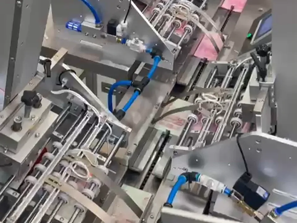 Alimentadores automáticos con producto plano impreso de color rosa, sobre la cinta de carga