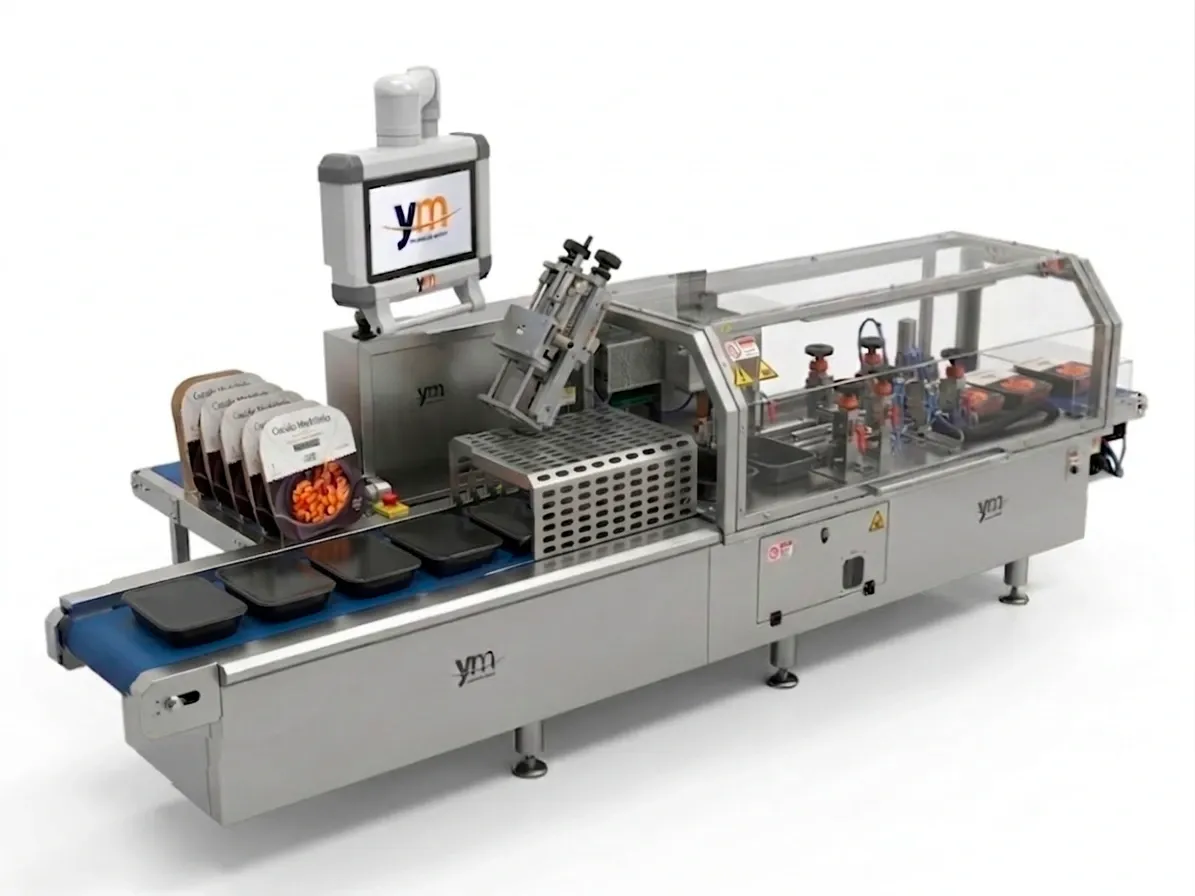 Machine de sleeving de YM Packaging posant des fourreaux en carton sur des barquettes de plats préparés